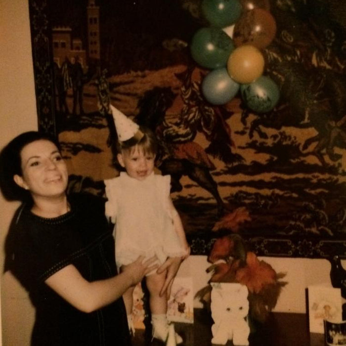 mom holding me at my first birthday party