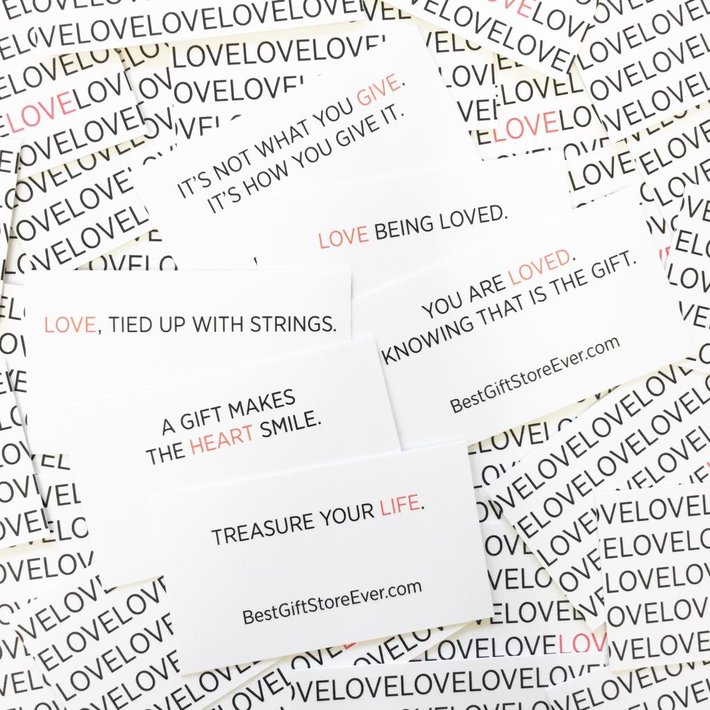 A bunch of BestGiftStoreEver business cards with the word love.